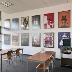 Czytelnia Cichej pracy na 4. piętrze: stanowiska do pracy, w tle ściana ozdobiona plakatami filmowymi